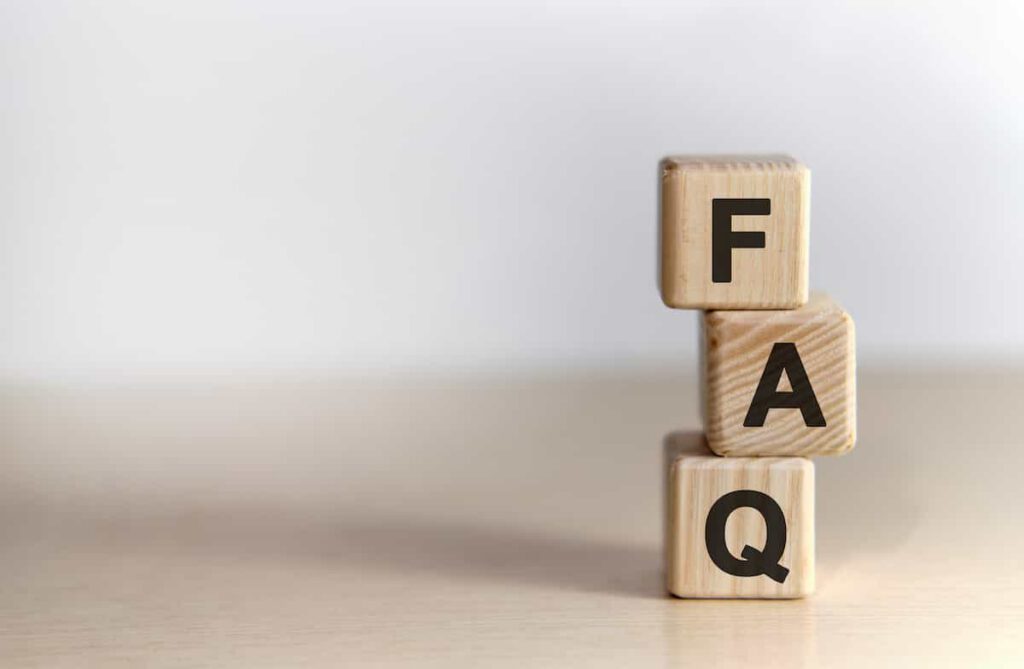 Three wooden blocks stacked vertically on a light surface, each displaying a black letter. From top to bottom, the blocks spell "F", "A", and "Q", representing the abbreviation for frequently asked questions.
